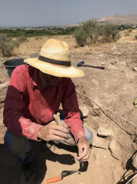 Dr. Cobb excavates and examines a bone. Photograph by Yadian Wang.
